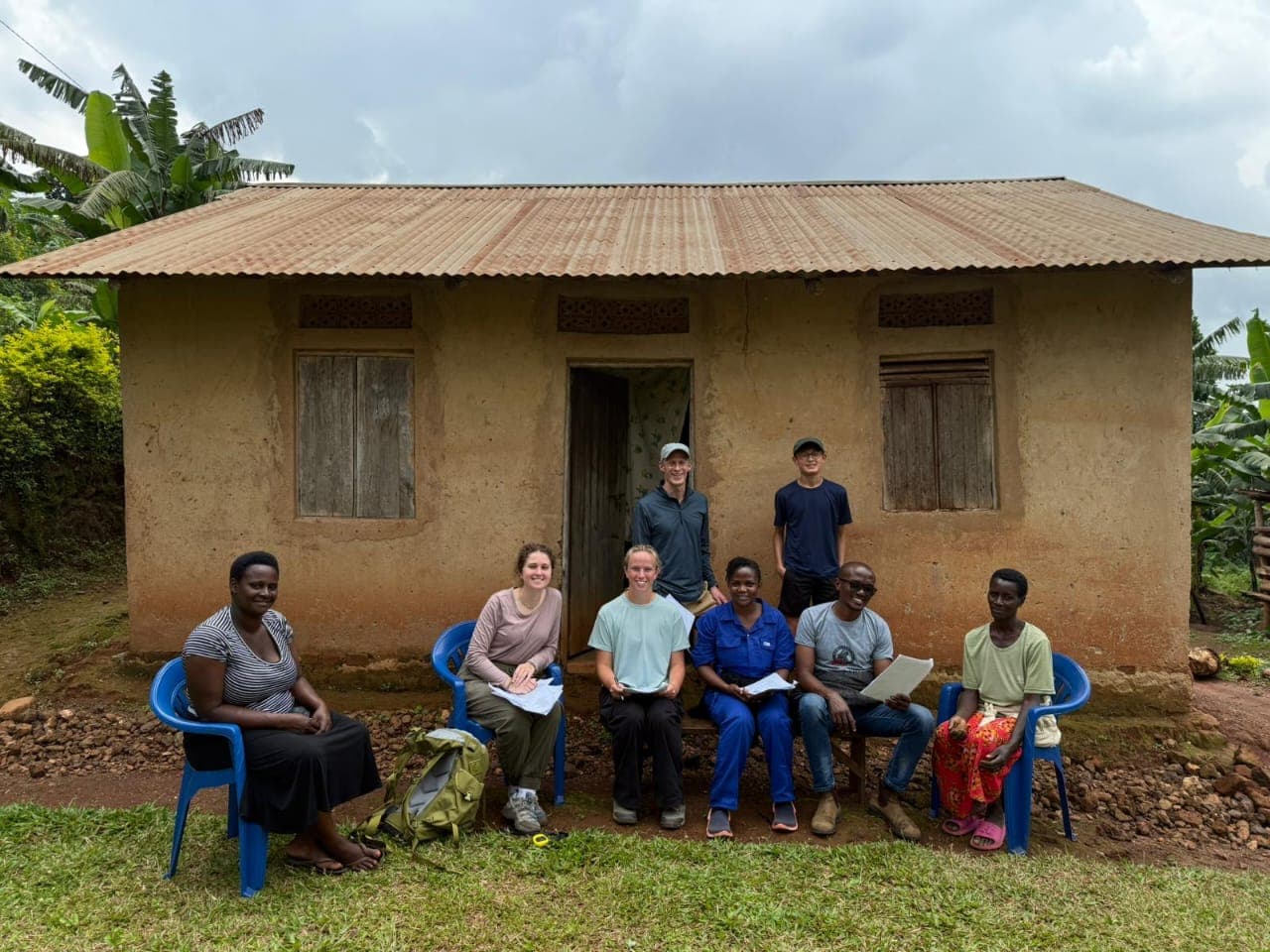 Research team conducting structured household interviews with local community members outside a residence.